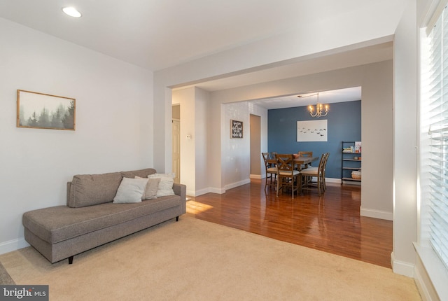 carpeted living room with an inviting chandelier