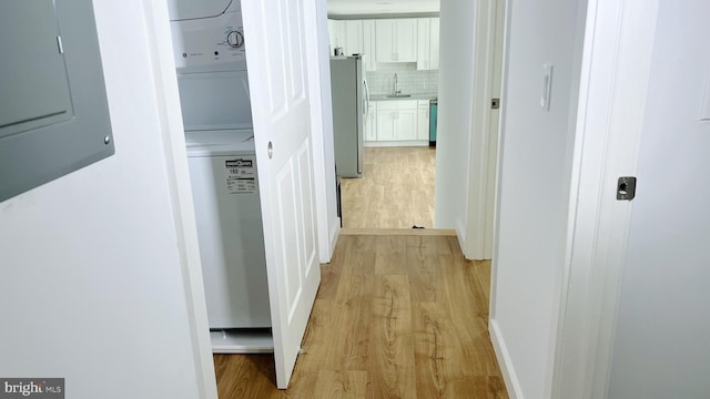 hall featuring electric panel, sink, and light wood-type flooring