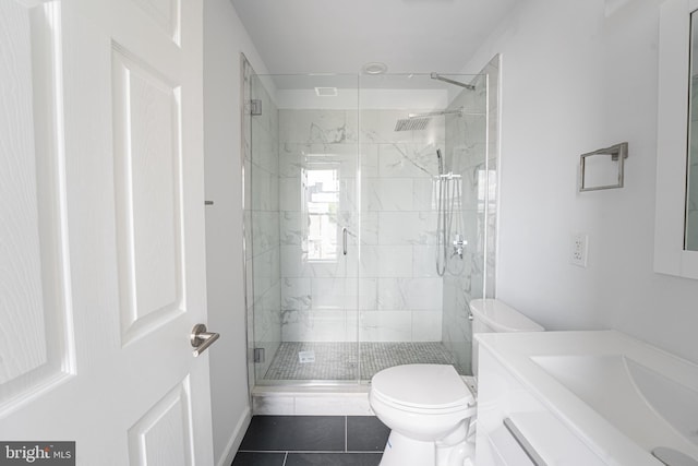 bathroom featuring toilet, vanity, tile patterned floors, and an enclosed shower