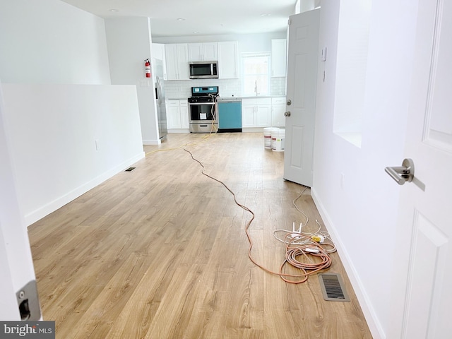 unfurnished living room with light hardwood / wood-style floors and sink