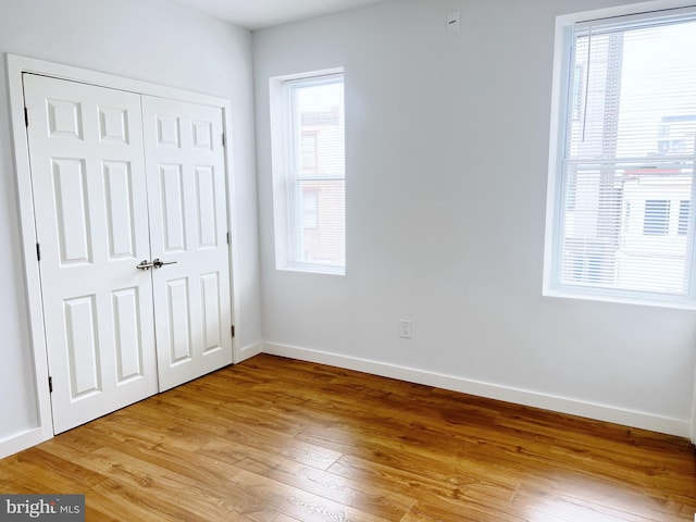 unfurnished bedroom with wood-type flooring and a closet