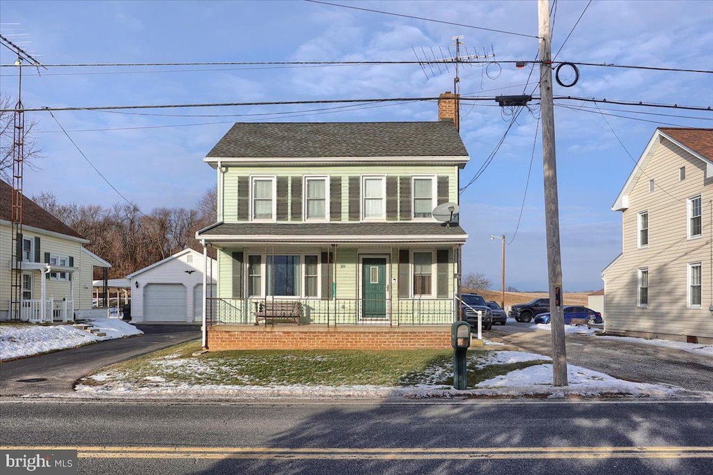 view of front of home with a garage, an outdoor structure, and covered porch