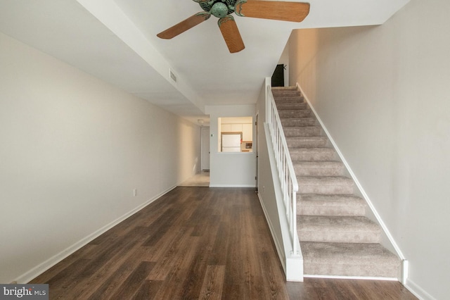 staircase featuring ceiling fan and wood-type flooring