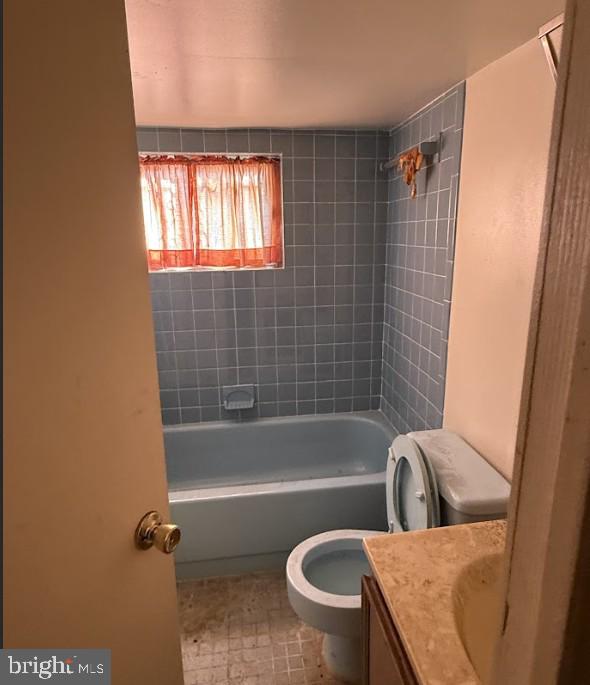 full bathroom featuring vanity, toilet, and tiled shower / bath combo