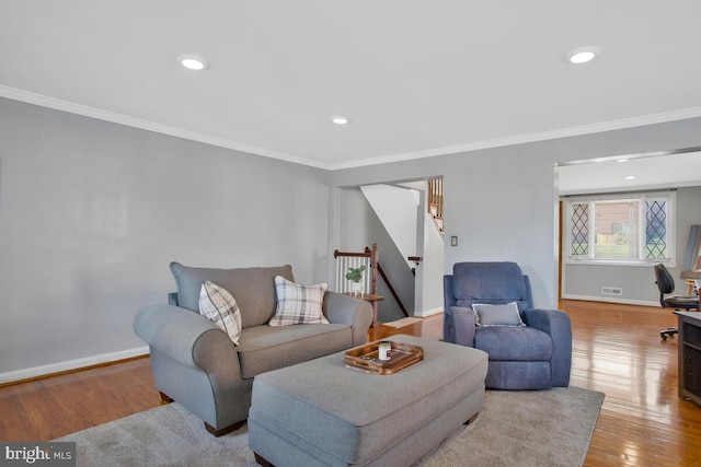 living room featuring crown molding and light hardwood / wood-style flooring