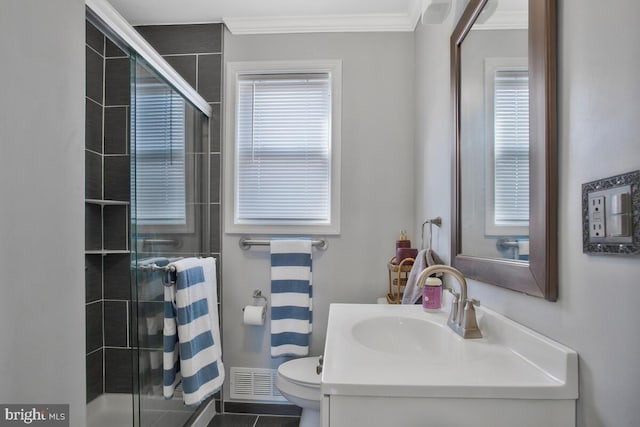 bathroom featuring vanity, a healthy amount of sunlight, toilet, and walk in shower