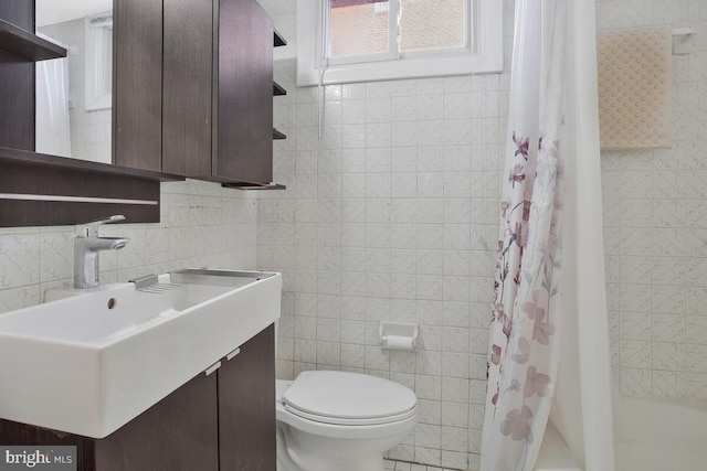 full bathroom with vanity, shower / bathtub combination with curtain, toilet, and tile walls