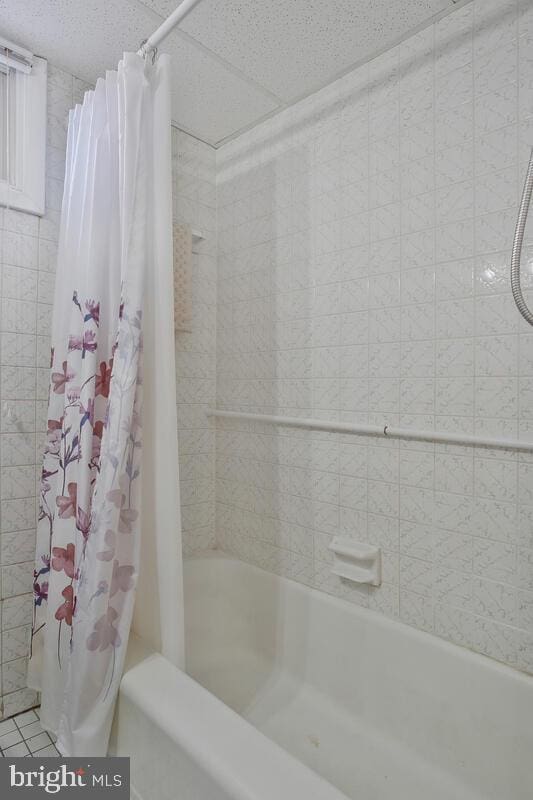 bathroom with tile patterned flooring and shower / tub combo with curtain