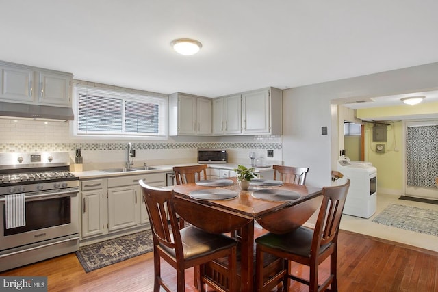 kitchen with hardwood / wood-style floors, sink, gray cabinets, tasteful backsplash, and stainless steel appliances