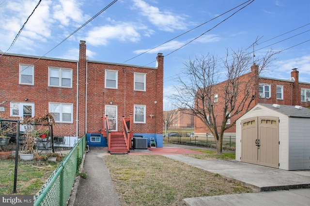 exterior space with a yard, central AC unit, and a storage shed