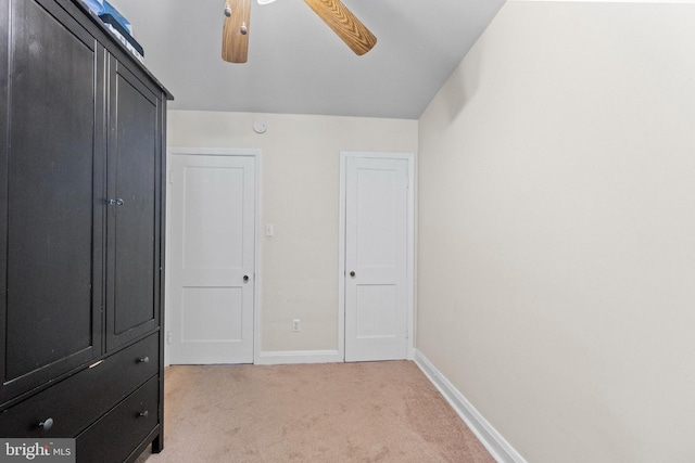 unfurnished bedroom with ceiling fan and light colored carpet