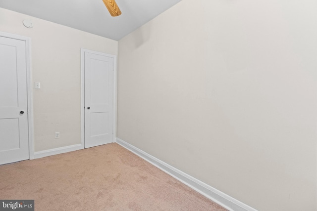 carpeted spare room featuring ceiling fan