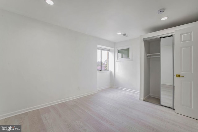 unfurnished bedroom featuring a closet and light wood-type flooring