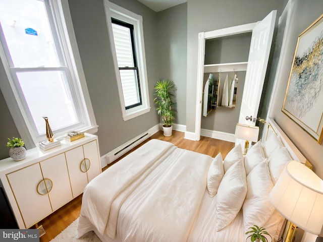 bedroom featuring light hardwood / wood-style flooring and baseboard heating