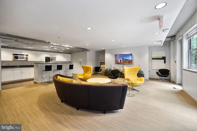 living area with baseboards, recessed lighting, and light colored carpet