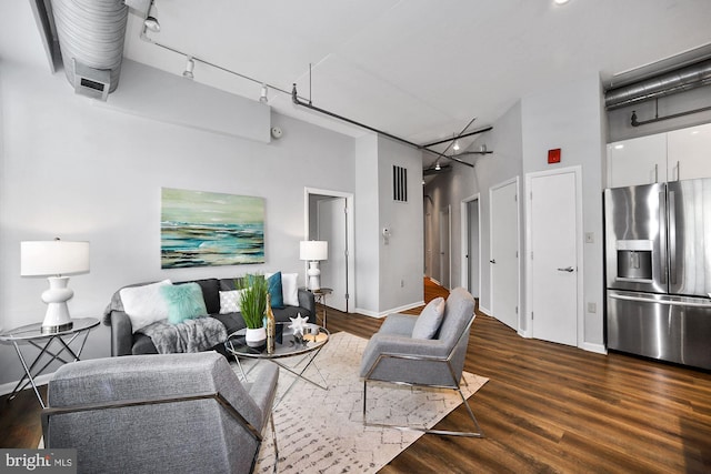 living room featuring dark wood-type flooring and a high ceiling