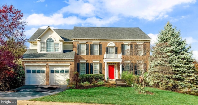 view of front of home featuring a balcony, a front yard, and a garage