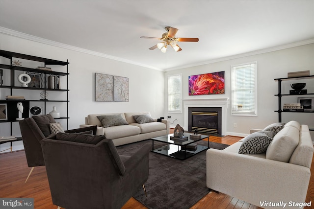 living room with a wealth of natural light, ceiling fan, wood-type flooring, and ornamental molding