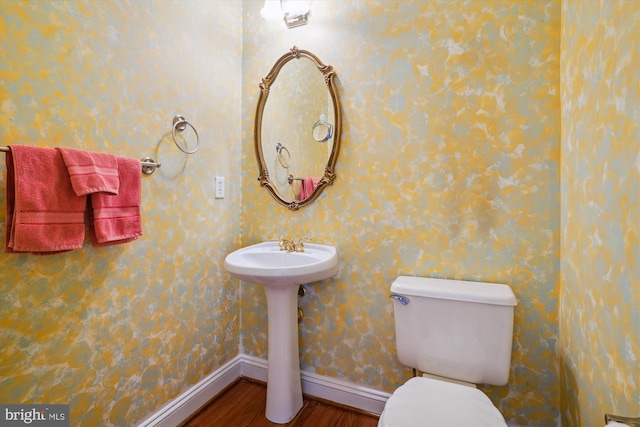 bathroom featuring hardwood / wood-style flooring, toilet, and sink