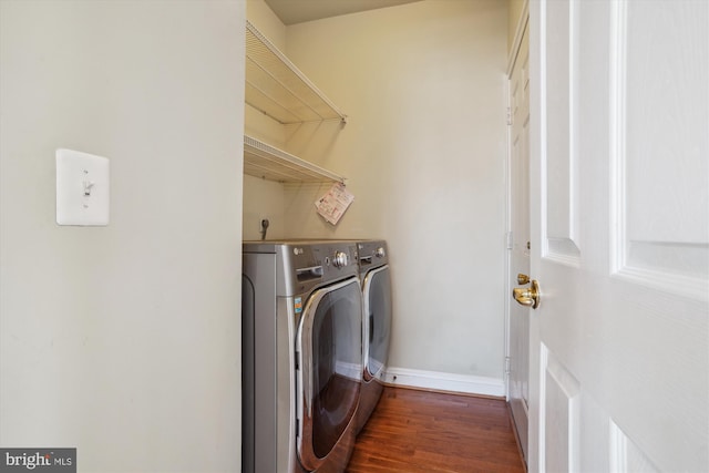 laundry area with washer and dryer and dark hardwood / wood-style flooring