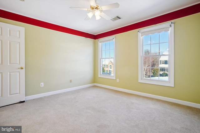 spare room with ceiling fan and light colored carpet