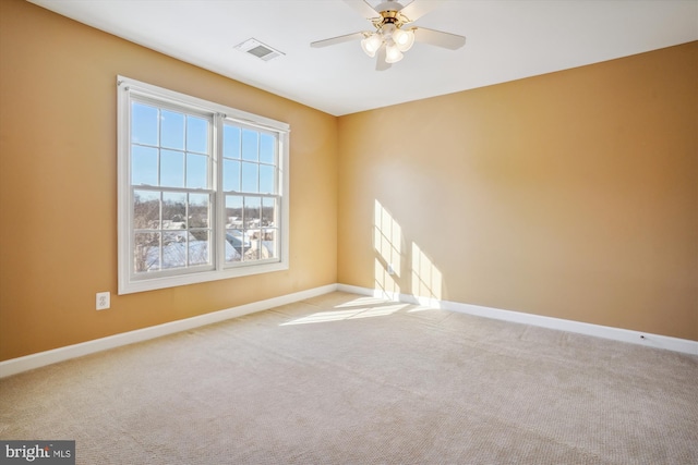 carpeted spare room with ceiling fan