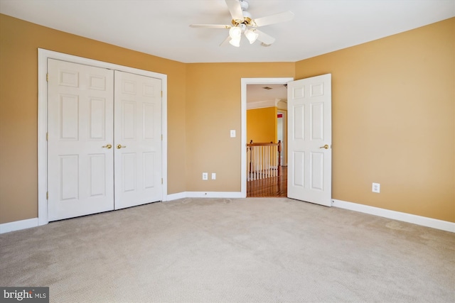 unfurnished bedroom featuring ceiling fan, light colored carpet, and a closet