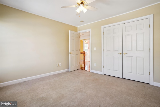 unfurnished bedroom featuring ceiling fan, a closet, and light colored carpet