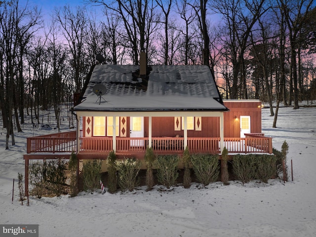 snow covered rear of property featuring a deck