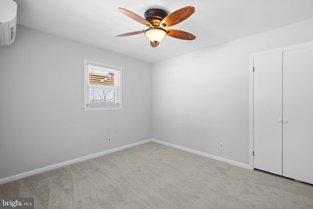 spare room with ceiling fan and light carpet