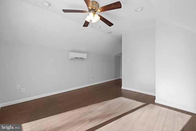 bonus room with wood-type flooring, a wall mounted AC, lofted ceiling, and ceiling fan