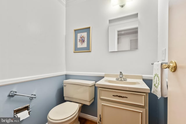 bathroom with ornamental molding, vanity, and toilet