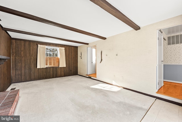 empty room with wood walls and beamed ceiling