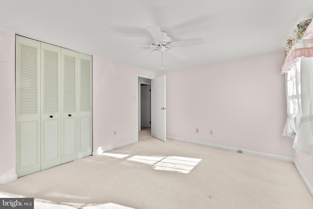 unfurnished bedroom with light carpet, a closet, and ceiling fan