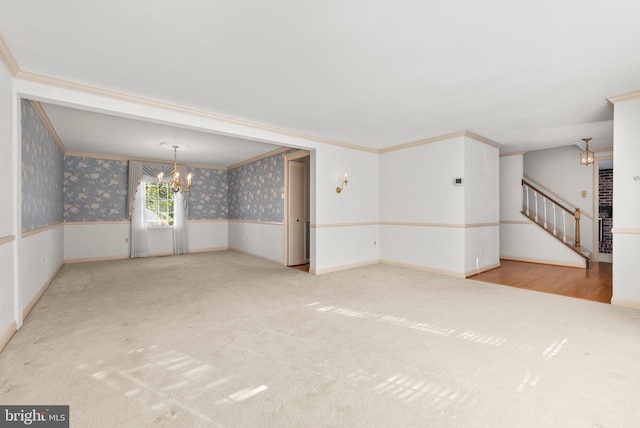 empty room featuring a chandelier, ornamental molding, and light colored carpet