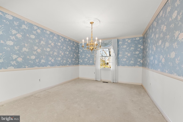 empty room featuring carpet floors, a notable chandelier, and crown molding