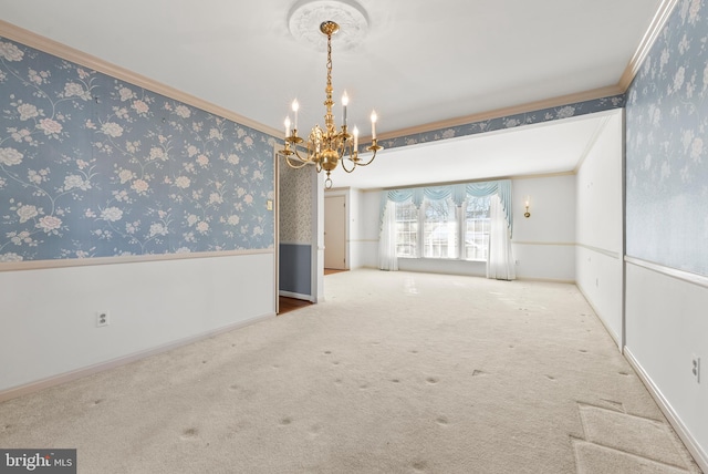 unfurnished room featuring carpet floors, ornamental molding, and a notable chandelier