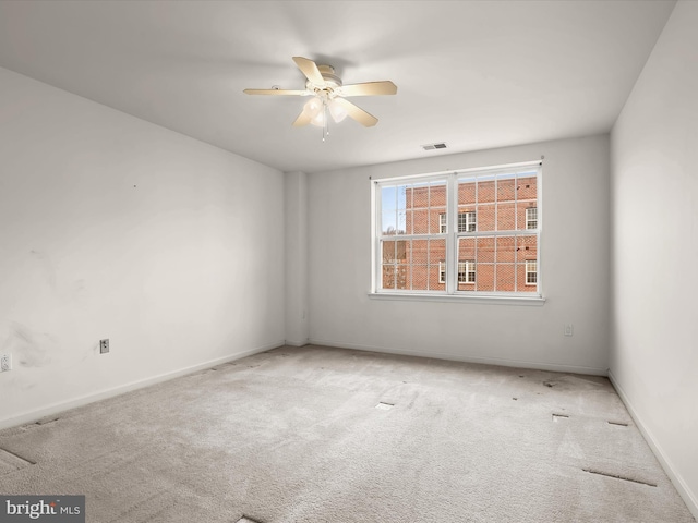 unfurnished room featuring visible vents, carpet floors, baseboards, and a ceiling fan