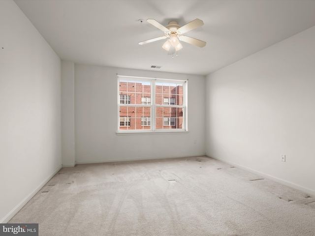 spare room with carpet flooring, baseboards, visible vents, and ceiling fan