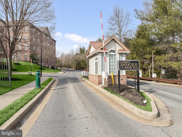 view of street with a gated entry and curbs