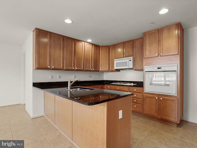 kitchen with white appliances, light tile patterned floors, a peninsula, recessed lighting, and a sink