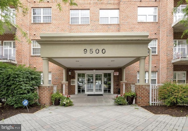 view of exterior entry with french doors and brick siding