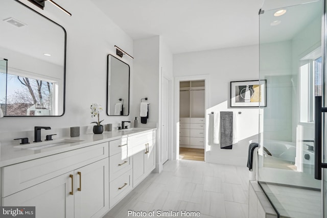 bathroom with a tub to relax in and vanity