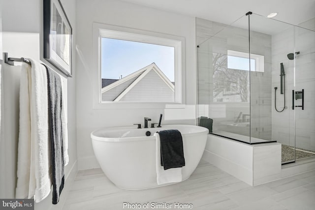 bathroom featuring shower with separate bathtub