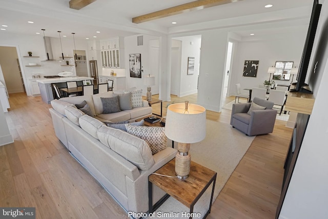 living room with beamed ceiling and light hardwood / wood-style flooring