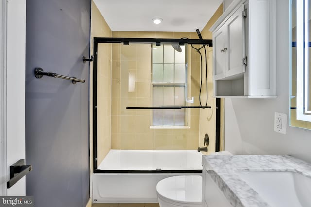 full bathroom featuring vanity, toilet, and bath / shower combo with glass door