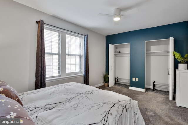 bedroom featuring multiple windows, ceiling fan, two closets, and dark colored carpet