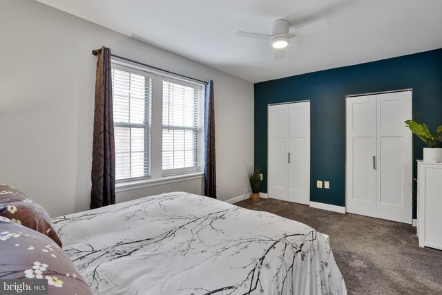 carpeted bedroom with ceiling fan and multiple closets