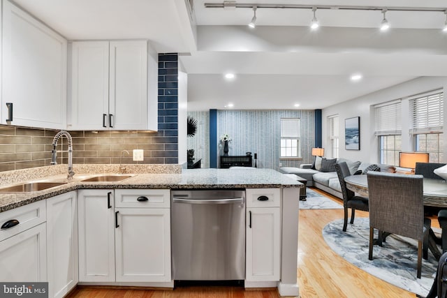 kitchen with white cabinets, dishwasher, light wood-type flooring, and sink