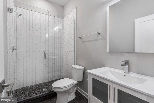 bathroom featuring tile patterned floors, vanity, toilet, and a shower with door